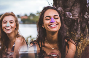 Happy girls wearing bold eco-friendly spf sunscreen on their noses